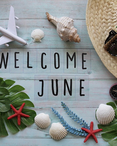 The image features travel and beach items, such as a plane, hat, sunglasses, and shells, surrounding the text 