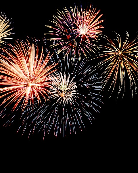 A display of colorful fireworks exploding against a dark night sky, creating a vibrant and festive scene full of light and energy.