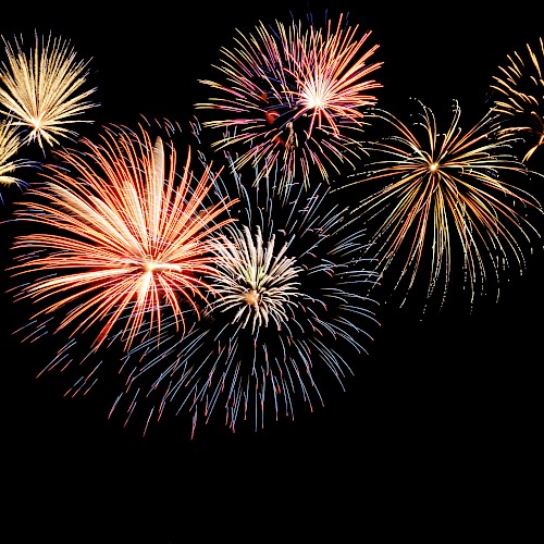 A display of colorful fireworks exploding against a dark night sky, creating a vibrant and festive scene full of light and energy.