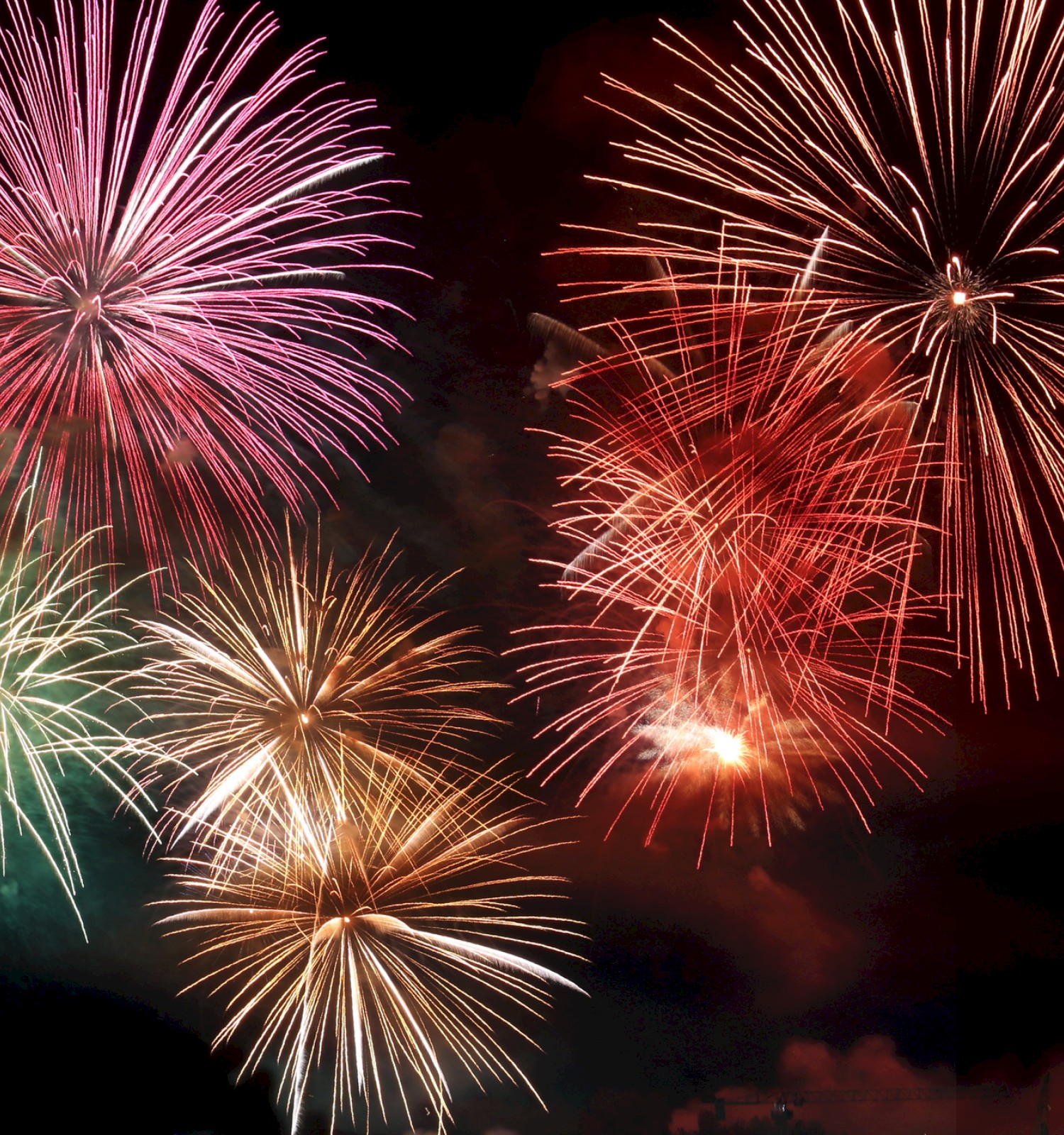 A vivid display of colorful fireworks bursts in the night sky, creating a dazzling and festive atmosphere.