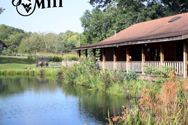 The image shows a serene pond next to a rustic building surrounded by lush greenery with the text 